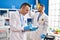 Two men scientists writing on document holding test tube at laboratory