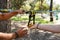 Two men setting up slacklining equipment in city park during summer day