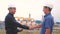 Two men shake hands working engineers work at a gas plant producing gas oil. handshake contract industry business