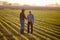 Two men shaking hands in corn field reaching agreement