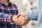 Two men shaking hands to dealing success agreement business. Business people wearing scott shirt on city view background