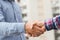 Two men shaking hands to dealing success agreement business. Business people wearing scott shirt on city view background