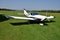 Two men sit into ultralight propeller-driven airplane and get ready for taking off