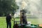 Two Men Starting up a Miniature Steam Engine.