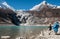 Two men stone skipping with view of snow covered Mount Manaslu 8 156 meters with Birendra Lake in the foreground in Himalayas