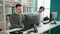 Two men students using computer writing on notebook at library university