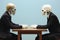 Two men in suits sitting at a table with skeleton heads on their heads. AI.