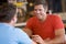 Two men talking over beer in a bar