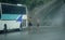 Two men topless cleaning the bus with brush on the road while heavy rain falling. Gurzuf, Crimea