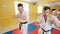 Two men training their aikido skills in the bright studio. Training their fistfights