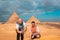 Two men travelers posing in front of the great pyramids of giza in cairo egypt. Traveling egypt during the winter, cold winter