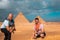 Two men travelers posing in front of the great pyramids of giza in cairo egypt. Traveling egypt during the winter, cold winter