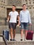Two men travelers in shorts with luggage walking
