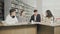 Two men and two women college students laughing while preparing for exams while sitting at table at university library