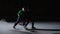 Two men in uniforms and helmets with hockey sticks skate on the ice arena, collide, dribbles and hitting puck