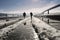 Two men walking across a snowy iron bridge, Georgia. photo 1/4