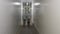 Two men in white special suits move through a white gloomy corridor. Two employees walk in the corridor of the company