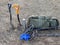 Two metal detectors shovel backpack thermos stand on dry grass