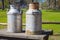 Two metal milk churns on wooden table