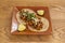 Two Mexican tacos with wheat tortillas stuffed with osso buco birria with pieces of lime to garnish