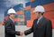 Two of Mid adult businessman shaking hands near cargo container