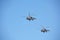 Two military helicopters against the blue sky.