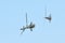 Two military helicopters flying on side in formation