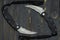 Two military knives on a black background. Two semicircular knives.