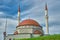 Two minarets and newly established mosque with its red color dome