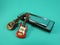 Two miniature electric guitars leaning against a silver diatonic harmonica