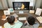 Two mixed-race diligent schoolchildren listening to teacher during online lesson