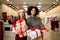 Two mixed race women with gift boxes in hands at store. Multi ethnic girls smiling with presents on christmas new year