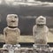 Two moai in Easter Island against grey sky