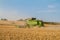 Two modern combine harvester cutting crops corn wheat barley working golden field