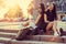 Two modern females posing on stairs.