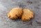 Two molasses cookies on gray mottled background side view