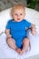 A two-month-old baby sits in a chair