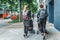 Two mothers on maternity leave walk with their children in strollers through the streets of the city