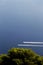 Two motorboats against a blue sea and trees