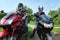 Two motorcyclists standing on country road