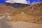 Two Motorcyclists on the Winding Mountain Road in the High-Altitude Mountain Desert in the Himalayas