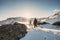 Two mountaineer hiking to peak mountain on snow field at sunset