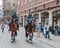 Two mounted policemen patrol the street in center