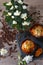 Two muffins, aroma coffee grains and flowers of azalia on gray wooden background. Top view.