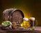 Two mugs of chilled beer, beer cask and bag of beer hops on wooden table