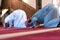 Two muliethnic religious muslim young people  praying and reading Koran together. Group of muslims praying in the mosque