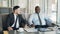 Two multi-ethnic businessmen discussing startup ideas in glassy cafe during lunch time. Coffee cup, financial graphs and