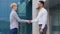 Two multiethnic colleagues arabic man and caucasian woman business partners stand outdoors near company building talking