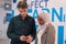 Two multiethnic college students standing in corridor and chatting after their class. Two college students talking and laughing