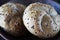 Two multigrain buns with sesame seeds and flaxseed on a brown plate